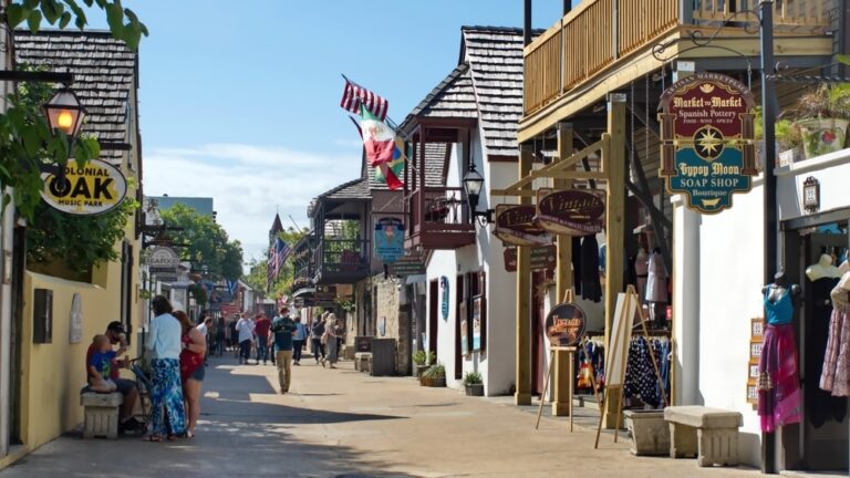 Enjoy a walking tour of historic St. Augustine. View of St. George Street, with shops and people walking.